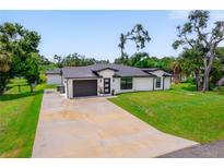 Beautifully landscaped home with a well-manicured lawn and a freshly painted exterior, showcasing its curb appeal at 326 Randolph Rd, Venice, FL 34293