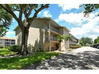 Exterior of a well-maintained two-story condo building with balconies and mature landscaping at 3985 Maceachen Blvd # 224, Sarasota, FL 34233