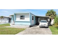 Charming single-story home with a well-maintained lawn, driveway, and mature landscaping at 5233 Kenwood Ave, Sarasota, FL 34234