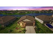 Beautiful single-Gathering home featuring a well-manicured lawn and a stunning lake view at sunset at 5327 Olano St, Palmetto, FL 34221