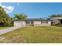 Charming single-story home with a well-manicured lawn and a classic neutral-toned facade at 6961 Alken Cir, New Port Richey, FL 34653
