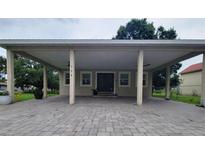 Charming single-story home with a large covered parking area and brick-paved driveway at 328 20Th W St, Palmetto, FL 34221
