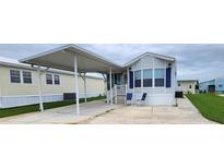 Charming mobile home featuring a covered parking and a well maintained green lawn at 3333 26Th E Ave # 1145, Bradenton, FL 34208