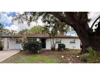 Charming single-story home featuring a textured exterior and a well-maintained front yard with mature trees at 4661 Linwood St, Sarasota, FL 34232