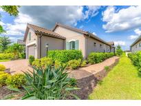 Charming home exterior with beautiful landscaping, a brick walkway and a tile roof at 3025 Veneto Ct, Bradenton, FL 34211