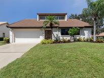Charming single Gathering home with a two-car garage, beautiful lawn and front yard landscaping at 154 Inlets Blvd, Nokomis, FL 34275