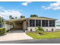 Charming home featuring a covered carport, screened-in porch, and well-manicured lawn with landscaped planters at 170 Edgewood Dr, Osprey, FL 34229
