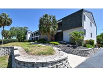 Condo exterior features manicured landscaping, stone accents, and a well-maintained walkway leading to the entrance at 2124 Tamiami N Trl # 103, Sarasota, FL 34234