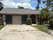 Modest single story home with a two car garage and red front door at 303 70Th Nw St, Bradenton, FL 34209