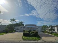 Well-maintained gray home featuring landscaping and a large driveway at 3324 Laurel Oak Way, Sarasota, FL 34237