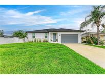 Charming one-story home with manicured lawn, gray garage door, and lush tropical landscaping at 4314 Des Plaines Dr, Sarasota, FL 34233