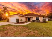 Charming single-story home featuring a well-manicured lawn, two-car garage, and a welcoming entrance under a striking sunset sky at 4649 72Nd E Ct, Bradenton, FL 34203