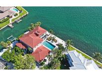 Stunning aerial view of waterfront property featuring a private pool, lush landscaping, and red-tiled roof at 585 Gunwale Ln, Longboat Key, FL 34228