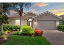 Charming home featuring a beautiful landscaped yard with mature palm trees and a brick driveway at 11550 Blackfin St, Venice, FL 34292