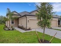 Charming home featuring a two-car garage, lush lawn, and stone-paved driveway at 18068 Cherished Loop, Bradenton, FL 34211