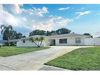 Charming single-story home featuring a well-manicured lawn, palm trees, and a long driveway at 2004 40Th W St, Bradenton, FL 34205