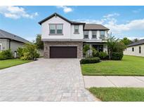 Beautiful two-story home with a stone facade and a well-maintained lawn and a brick driveway at 731 116Th Ne Ct, Bradenton, FL 34212