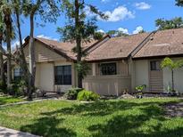 Inviting exterior view of a charming townhome with manicured lawn, mature landscaping and beige facade at 5231 Brassy Loop, North Port, FL 34287