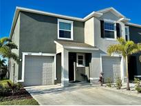 Attractive two-story townhome with attached garage and manicured landscaping at 8697 Milestone Dr, Sarasota, FL 34238