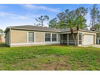 Tan one-story house with screened porch and attached garage at 1340 Papillon St, North Port, FL 34287