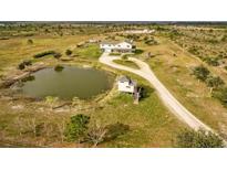 Aerial view showing the house, pond, and surrounding land at 48665 Bermont Rd, Punta Gorda, FL 33982