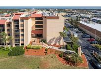 A multi-story building with a red roof, landscaping, and a parking lot at 3006 Caring Way # 325, Port Charlotte, FL 33952