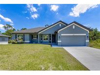 Charming single-story home featuring a two-car garage, well-manicured lawn, and inviting curb appeal at 3482 Dunkirk St, Port Charlotte, FL 33980