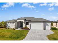 Single-story home with a two-car garage and landscaped front yard at 9445 Galaxie Cir, Port Charlotte, FL 33981