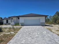 Charming single-story home featuring a two-car garage and patterned tile driveway at 8285 Agate St, Port Charlotte, FL 33981