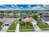 Attractive canal-front home with lush landscaping and two-car driveway at 234 Fields Se Ter, Port Charlotte, FL 33952