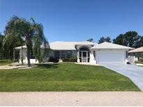 Single-story home with a white exterior, grey accents, and palm trees at 431 San Felix St, Punta Gorda, FL 33983
