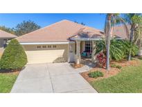 Single-story home with a two-car garage and landscaped yard at 1871 Mossy Oak Dr, North Port, FL 34287