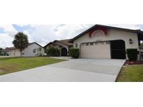 Two-car garage and front entrance of a charming house at 21445 Peachland Blvd, Port Charlotte, FL 33954