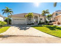 Tan two-story house with tile roof and palm trees at 3600 Kassandra Dr, Punta Gorda, FL 33950
