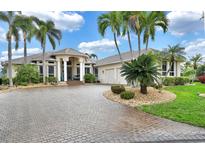Two-story home with tile roof, palm trees, and circular driveway at 1700 Los Alamos Dr, Punta Gorda, FL 33950