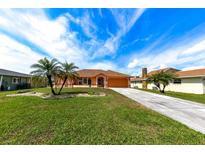 Attractive ranch home with palm trees, a manicured lawn, and a long driveway at 4115 Rock Creek Dr, Port Charlotte, FL 33948