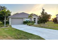 Well-maintained home with a large front yard and a two-car garage at 24479 Vienison Ln, Punta Gorda, FL 33955