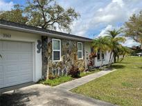 Ranch-style home with a stone facade and a two-car garage at 3303 Ithaca St, Port Charlotte, FL 33952