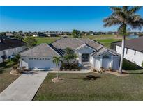 Single-story home with tile roof, two-car garage, and landscaped lawn at 3853 Bordeaux Dr, Punta Gorda, FL 33950