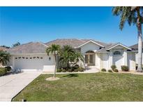 Single-story house with tile roof, landscaping, and driveway at 3853 Bordeaux Dr, Punta Gorda, FL 33950