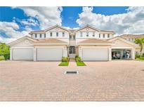 Three-unit building with attached garages and brick paver driveway at 17434 Boca Vista Rd # 1006, Punta Gorda, FL 33955