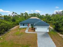 New construction home with gray exterior, gray driveway and landscaping at 14242 Imlay Ave, Port Charlotte, FL 33981