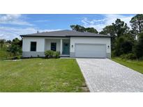 Modern single-story home with a gray paver driveway at 173 Edgemere Nw St, Port Charlotte, FL 33948