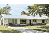 Charming single-story home with modern windows, stone accents, and a well-manicured lawn at 5731 Oakview Ln, Punta Gorda, FL 33950