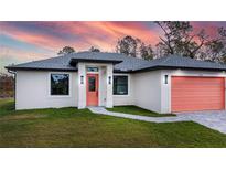 One-story house with a coral garage door and landscaped yard at 22528 Minerva Ave, Port Charlotte, FL 33954