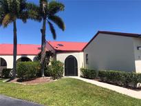 Charming condo building with red tile roof and lush landscaping at 3830 Bal Harbor Blvd # 2, Punta Gorda, FL 33950