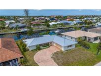 Aerial view of canal-front home with private dock and paved driveway at 103 Tropicana Dr, Punta Gorda, FL 33950