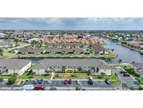 An aerial view of condo with beige exterior, parking and beautifully landscaped with waterfront and neighborhood views at 4000 Bal Harbor Blvd # 214, Punta Gorda, FL 33950