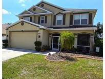 Two-story house with tan siding, brown shutters, and a landscaped yard at 10034 Winding River Rd, Punta Gorda, FL 33950