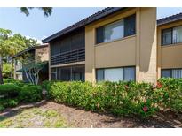 Charming two-story condo with a screened porch and well-maintained landscaping including vibrant flowering bushes at 5685 Ashton Lake Dr # 2, Sarasota, FL 34231